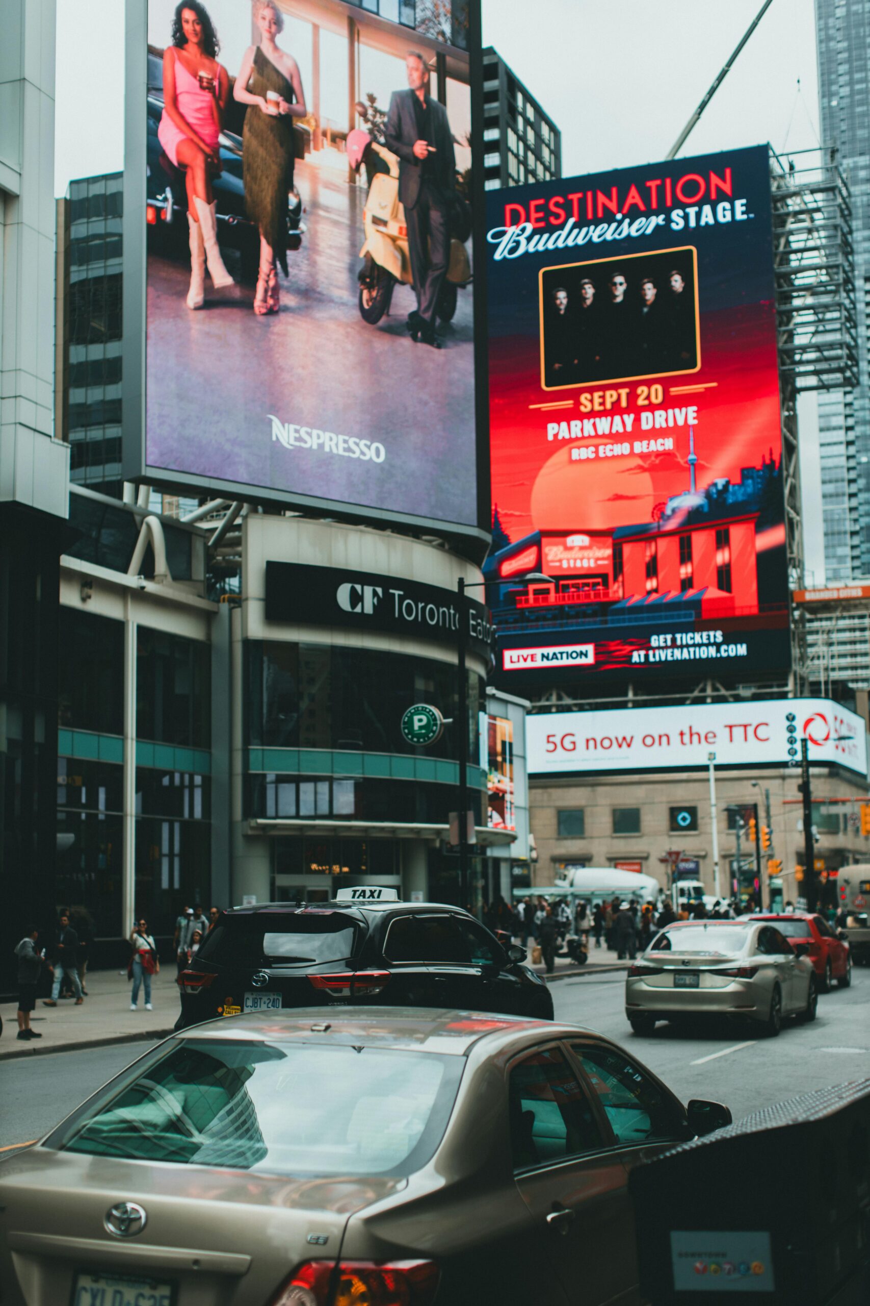 Dynamic city street scene featuring billboards and bustling traffic at CF Toronto Eaton Centre.